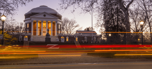 The UVA Rotunda seen from the street, with blurred streaks of lights from cars going by