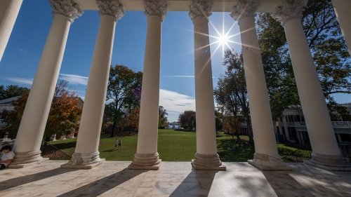 A view looking outwards on the the UVA Lawn from the rotunda. There are 8 pillars in the image at the top of the steps.