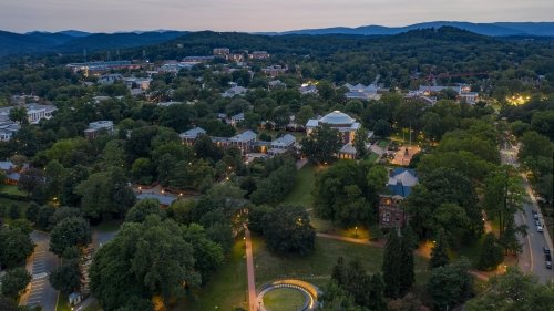 Aerial image of UVA Grounds at dusk with Blue Ridge Mountains in the background