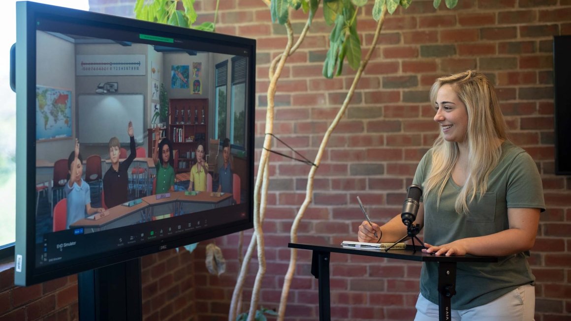 A young woman with blonde hair participates in a teaching simulation exercise