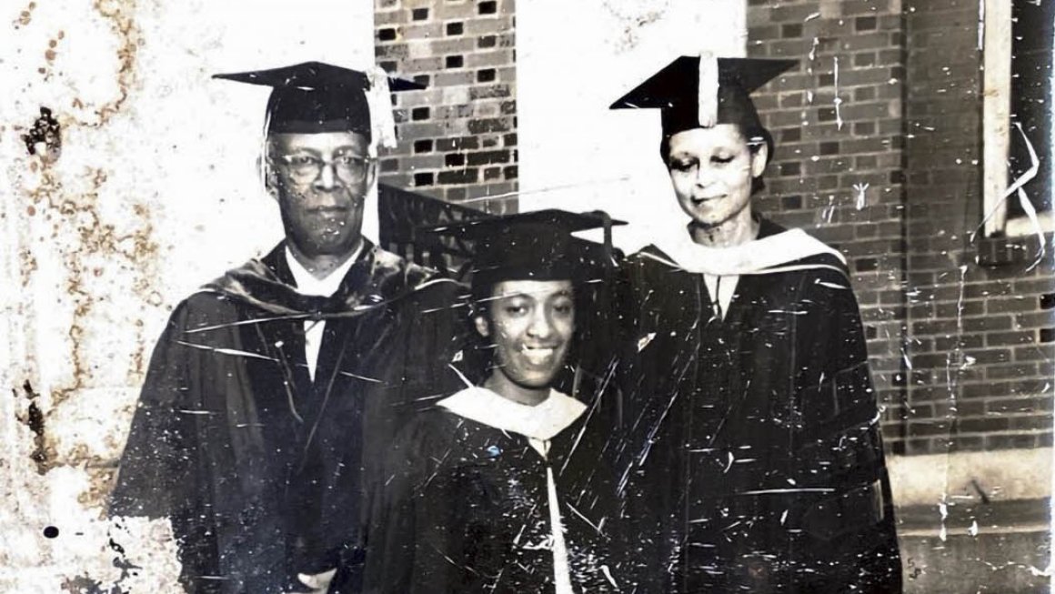 An old black-and-white photograph of three people wearing graduation caps and gowns