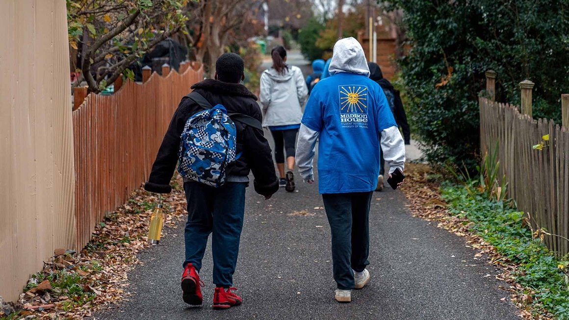 UVA student and Charlottesville student walking along sidewalk