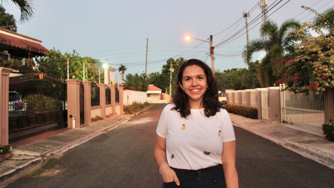 Katie MacDonald, wearing a white T-shirt, stands on a street in the Dominican Republic