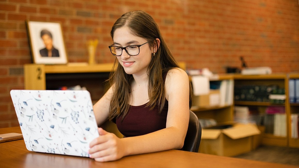 A female college student works on a laptop