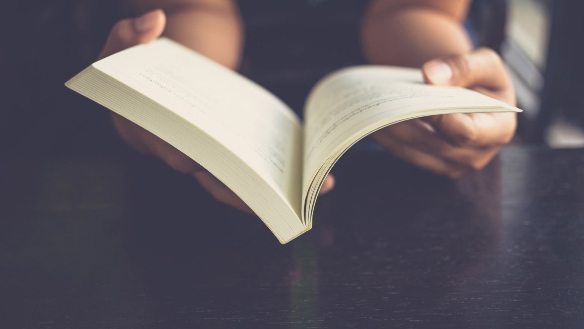 Person holding open book