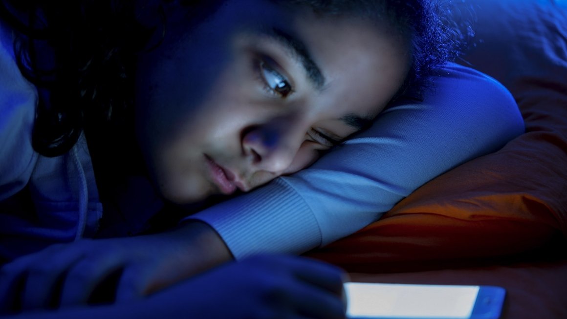 Kid using smartphone in bed