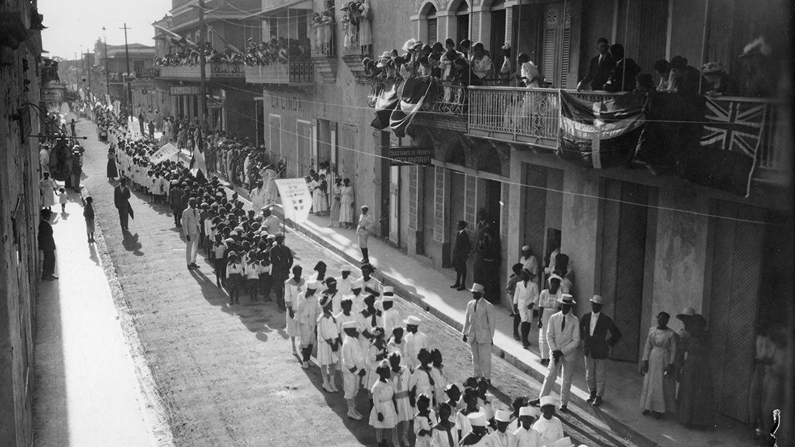 Black and white photo of a parade in the Dominican Republic celebrating the end of World War I.