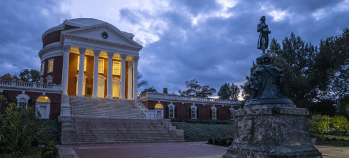 The UVA Rotunda shot from the Lawn at dusk with the statue of Thomas Jefferson in the foreground