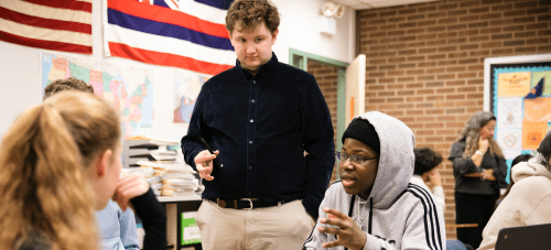 A group of students and a teacher having a discussion in class