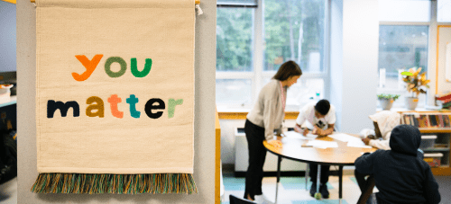 A tapestry hanging on a wall that says "you matter," in a classroom where there are students and a teacher working at a table in the background