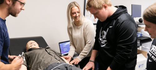 Athletic training faculty and students working together in a simulation lab