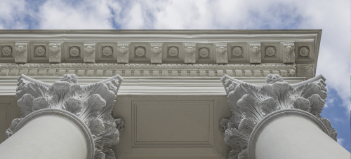 A picture featuring exterior architectural details on stone pillars a UVA building.
