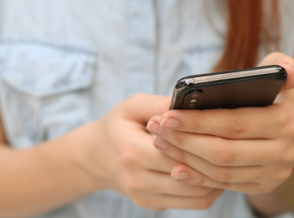 A zoomed-in photo of hands holding a smartphone