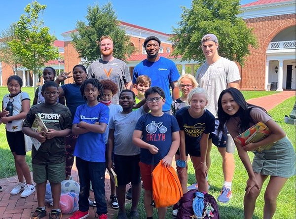 charlottesville-freedom-school_checkerboard_2022-06.jpg Young children and counselors smile at camera