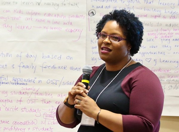 checkboard_student-conference_600x444.jpg Student holing a microphone giving a presentation