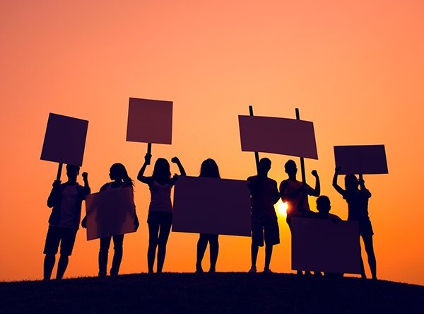 Silhouette of students standing and holding signs