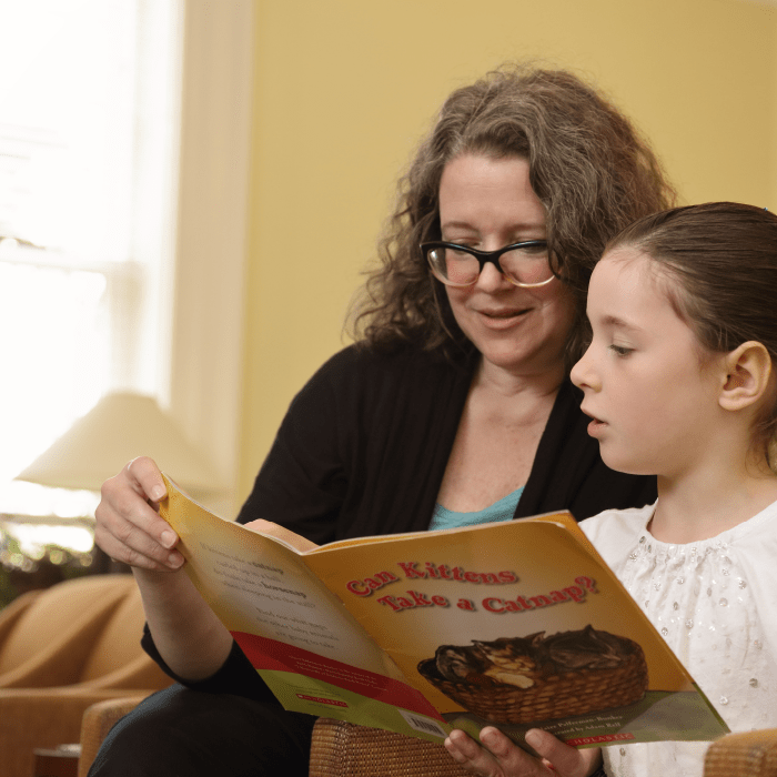 A reading specialist looking at a book with a young child.