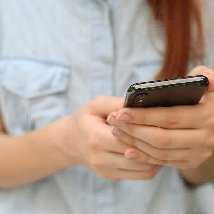 A zoomed-in photo of hands holding a smartphone