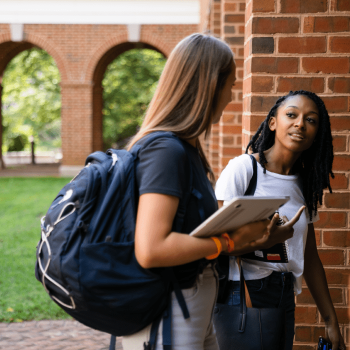 Two students conversing as they walk to class