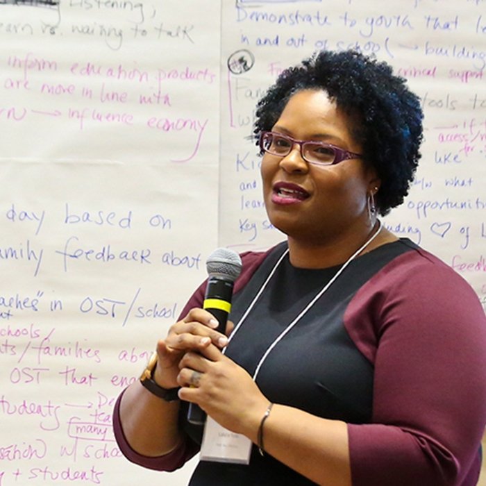 Woman stands and holds microphone