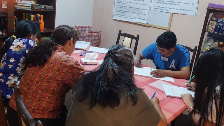 Five people sit around a table working