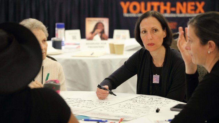 Bethany Teachman and other conference attendees conversing during a breakout session at the Youth-Nex Conference.