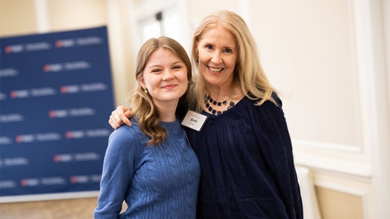 Two individuals posing for a photo at an event