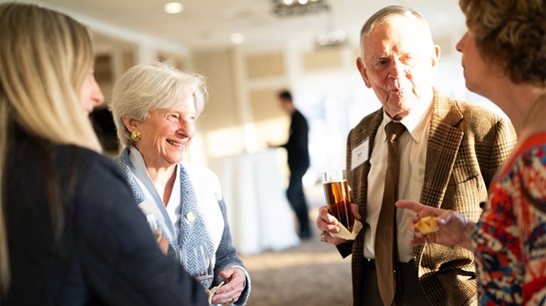 A group of people having a conversation at an event.