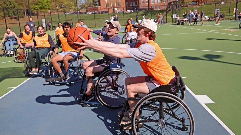 A group of people playing wheel chair basketball