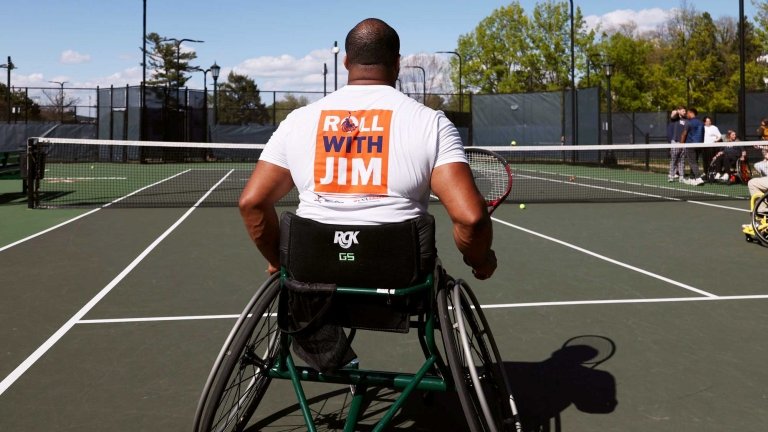 Brian Douglas in a wheelchair at a tennis court
