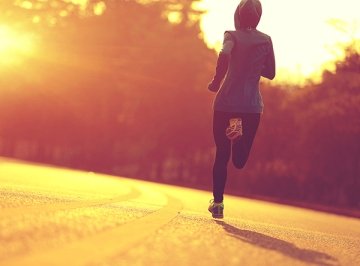 Jogger running away from the camera at sunset