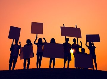 Silhouette of students standing and holding signs