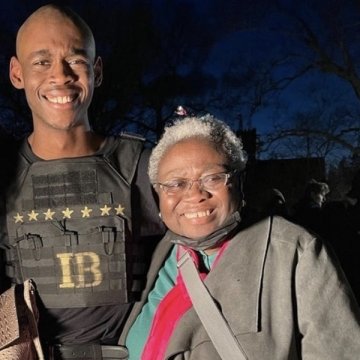 Isaac Henderson stands next to his grandmother.
